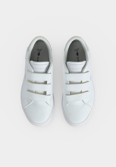 Двойка бели маратонки Lacoste с три велкрота, гледани отгоре на обикновен фон.