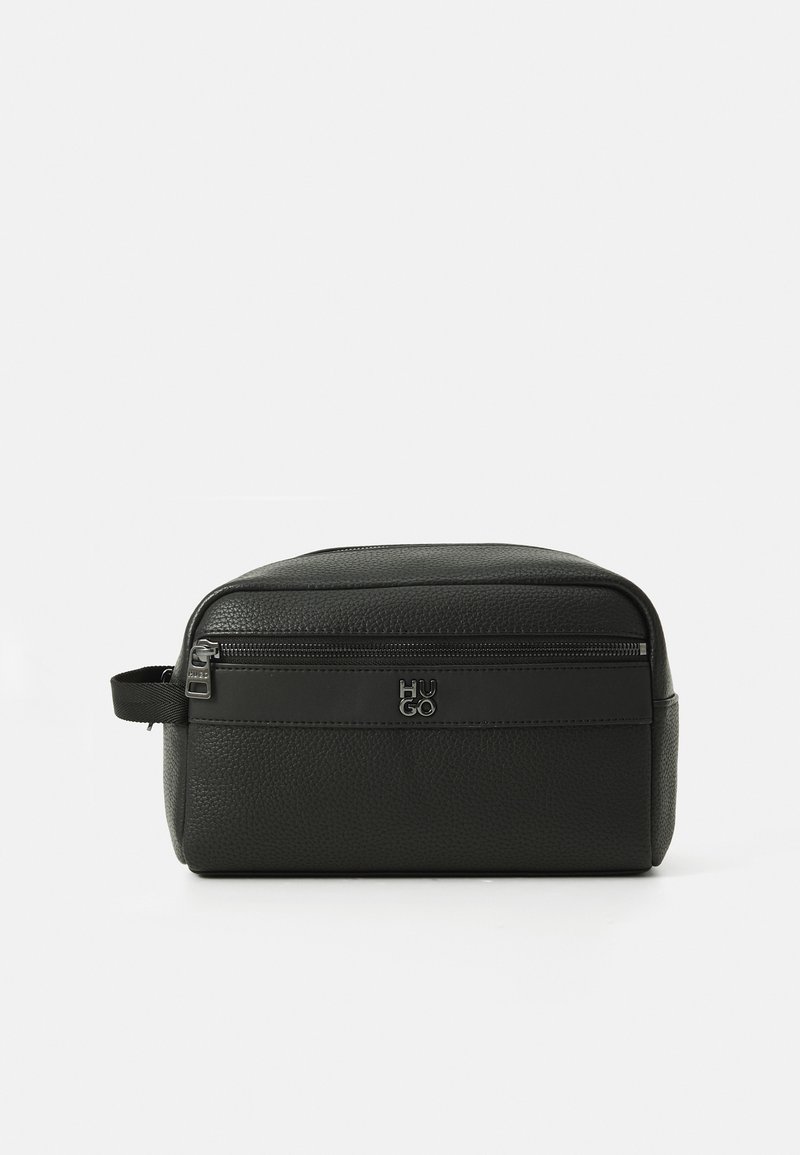Svart teksturert skinnrektangulær toalettveske med glidelås, sidehåndtak og metall Hugo-logo på frontlommen.