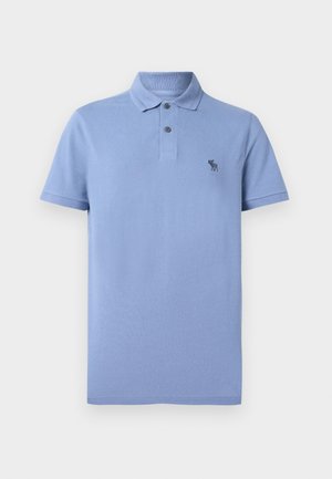 Lyseblå polo skjorte laget av teksturert stoff, med klassisk krage, to-knapps lukking og liten brodert logo på brystet.