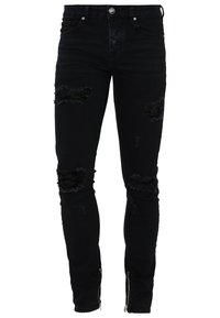 Jean noir slim-fit avec des patches usés sur les cuisses et les genoux, fermeture à boutons devant et fermetures éclair aux chevilles.
