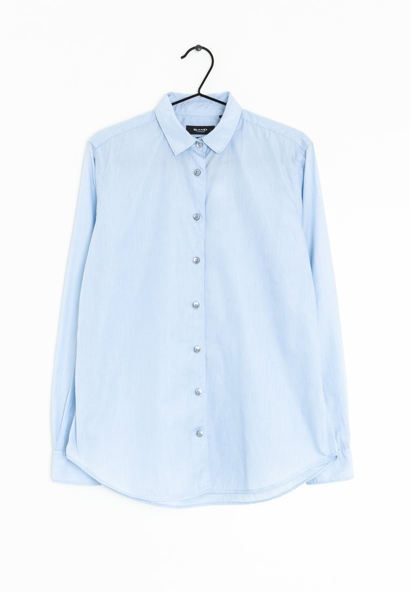 Camisa de botonera de manga larga en azul claro, hecha de una tela suave. Cuenta con un cuello, dobladillo redondeado y seis botones en la parte delantera.