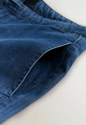 Denimjeans i en mellemblå farve med en blød tekstur, standard lommestørrelse og ren syning langs kanterne.