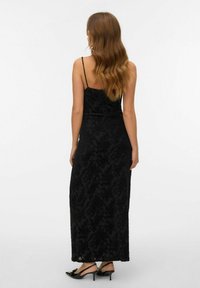 Melna maksi kleita ar plānām spageti lencēm, ar teksturētu ziedu rakstu, pieguļošs siluets un taisna apmala.