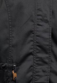 Černá látková bunda s hladkou strukturou, výrazným prošíváním a dřevěným akcentem na stahovací šňůrce; moderní design s elegantním vzhledem.