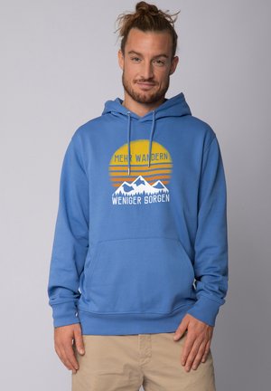 Blauwe hoodie met een voorste kangoeroezak, voorzien van een grafisch motief van bergen en een zonsondergang in geel en oranje, met tekst in het wit.