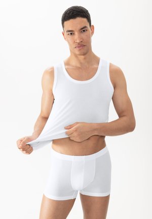 Witte katoenen tanktop en boxershort, beide van textuur met een netpatroon. De tanktop heeft brede armsgaten en een ronde hals.