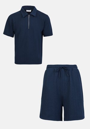 Polo navy à manches courtes avec un col zippé et une texture en losanges, associé à un short assorti avec une taille ajustable à cordon.