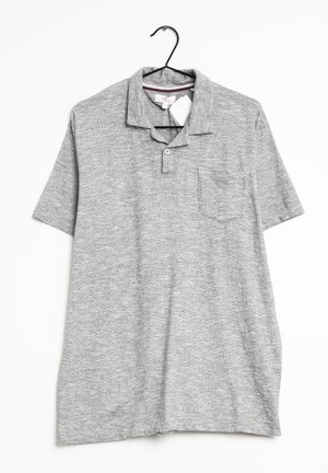 Grijze polo van gestructureerde stof, met een sluiting met twee knopen, korte mouwen en een borstzak. Hangt aan een zwarte haak.