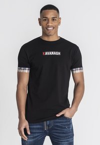 Camiseta de algodón negra con mangas cortas de estampado de cuadros. Presenta la palabra "KAVANAGH" impresa en rojo y blanco en el pecho.