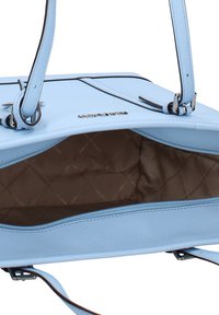 Borsa a mano in pelle azzurro chiaro con forma rettangolare, tasca interna con zip e fodera in tessuto marrone con motivo. Dettagli in metallo argentato visibili.