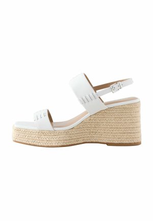 White wedge sandals with a textured jute platform and leather upper. Features an adjustable ankle strap and two strap design.