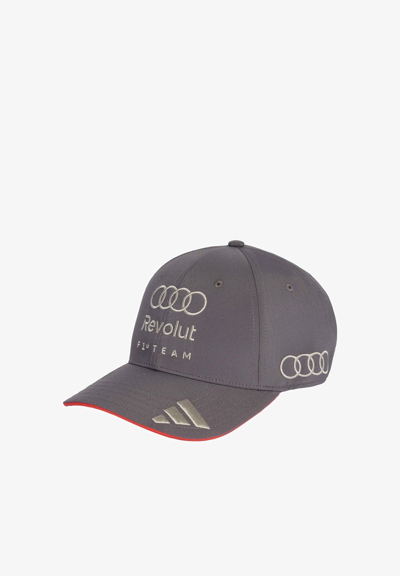 Casquette de baseball grise avec le logo des anneaux Audi, texte "Revolut F1 Team" sur le devant, et logo Adidas sur le bord de la visière avec une bordure rouge en dessous.