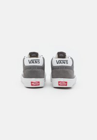 Sive visokotonirani tenisice od suède kože s bijelim detaljima, brendirane "VANS" na peti, s crvenim logotipom na bijelom potplatu.