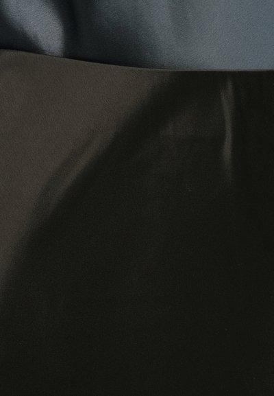 Nachodzące na siebie gładkie kawałki tkaniny w ciemnoszarym i czarnym kolorze, ukazujące miękkie fałdy i subtelne różnice w fakturze.