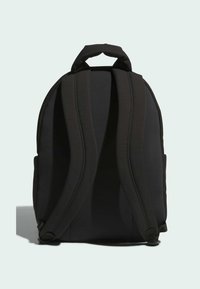 Černý batoh zobrazený ze zadní strany s dvěma polstrovanými ramenními popruhy a malou polstrovanou rukojetí nahoře na jednobarevném světlém pozadí.