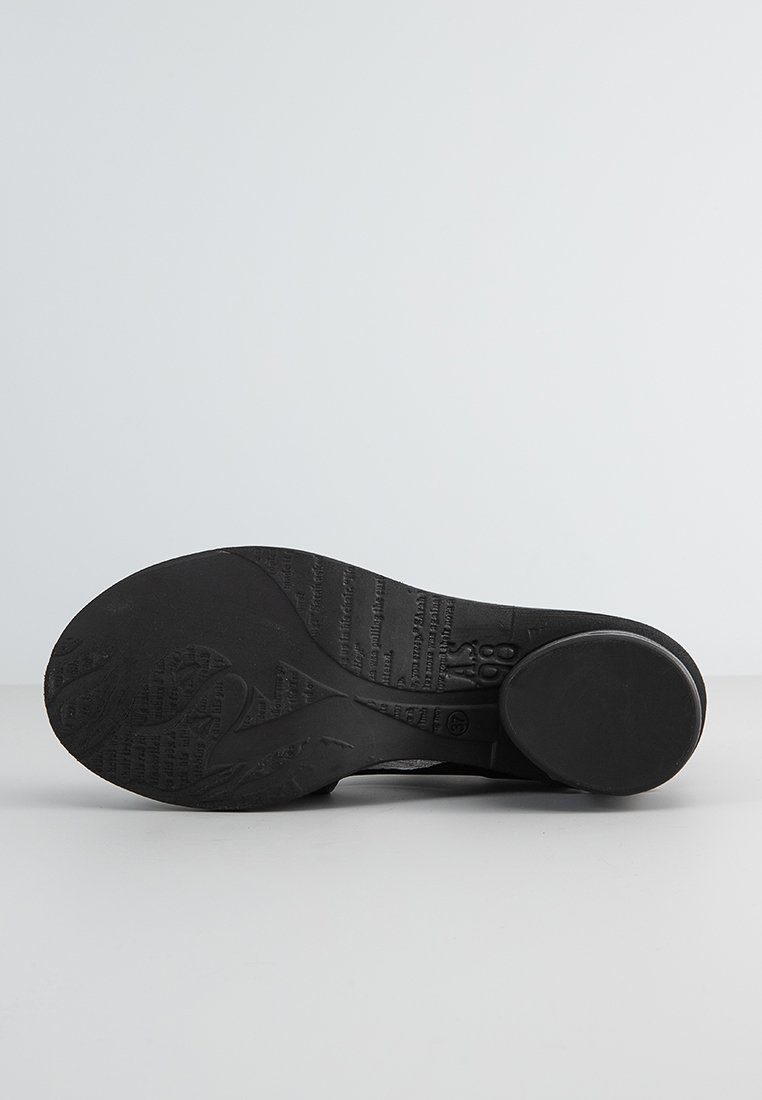 Czarna podeszwa buta z teksturowanymi wzorami i brandingiem. Okrągły obcas i gładkie krawędzie. Materiał wydaje się gumowy, zaprojektowany z myślą o przyczepności.