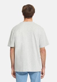 Lichtgrijs katoen T-shirt met een ontspannen pasvorm, korte mouwen en een ronde hals. Gladde textuur, geen zichtbare patronen of logo's.