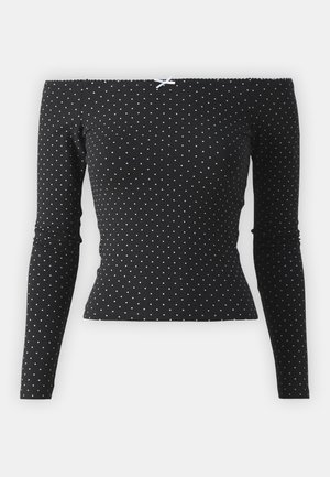 Μαύρο τοπ με ανοιχτούς ώμους και μακριά μανίκια, με λευκές βούλες και διακοσμητική ανοιχτό μπλε κορδέλα στο πίσω μέρος. Φτιαγμένο από μαλακό ύφασμα.