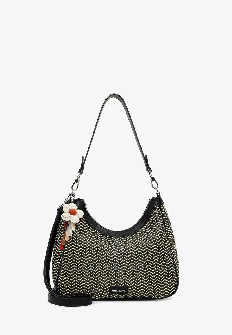 Bolso de hombro con patrón de zigzag en blanco y negro, con ribete y correas negras, decorado con una flor blanca y un llavero con charm multicolor.