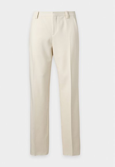 Pantalon beige droit sur mesure avec passants de ceinture et pli devant sur un fond clair uni.