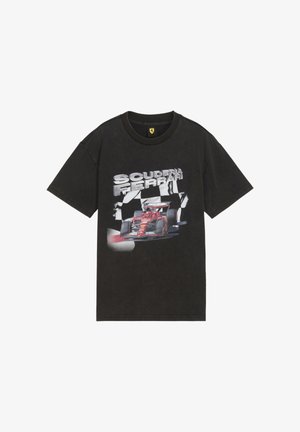 Svart bomull t-shirt med en grafisk design av en röd racingbil och "SCUDERIA FERRARI" i stora silverbokstäver. Korta ärmar, rundad hals.