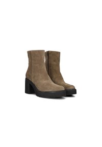 Bottes en cuir daim taupe à talon carré et semelle en caoutchouc noir. Elles disposent d'une fermeture éclair simple sur le côté. Texture lisse.