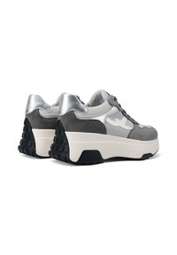 Le sneaker grigie e argento presentano una combinazione di materiali in suede e mesh, una soletta bianca spessa e una suola esterna in gomma nera testurizzata.