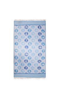 Blue and white beach towel with nautical patterns including anchors, fish, seahorses, sailboats, and crabs, framed by zigzag borders with fringes.
