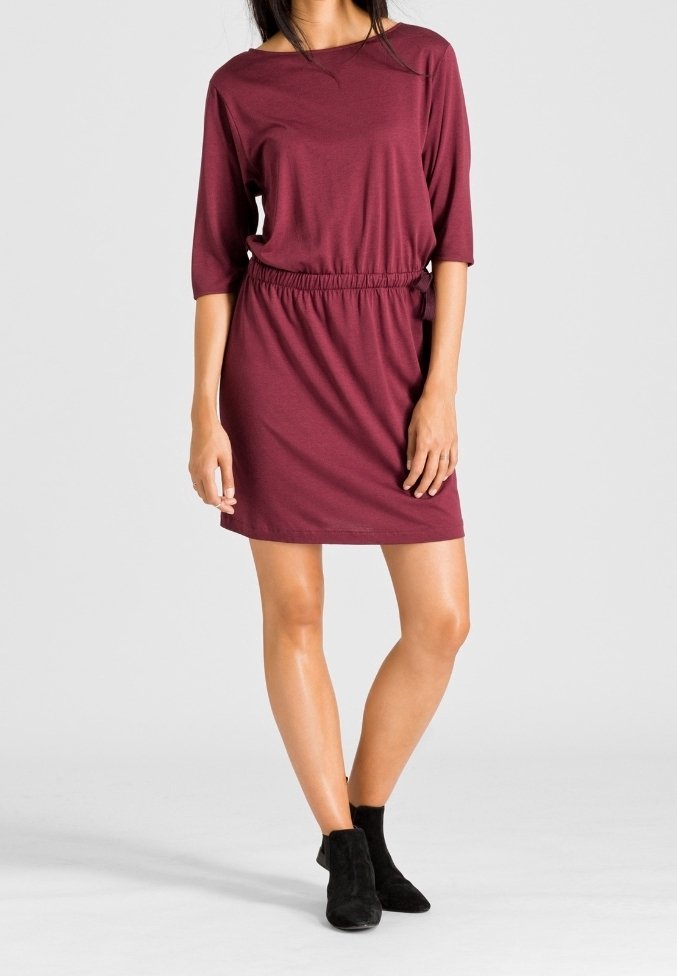 Burgundy short-sleeve dress with an elastic waist, made of soft fabric. Worn with black ankle boots, featuring a relaxed fit and above-knee length.