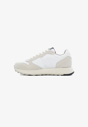 Sneakers grigi chiari e bianchi che presentano una combinazione di materiali in pelle e suede, con una suola testurizzata e accenti di design minimalista.