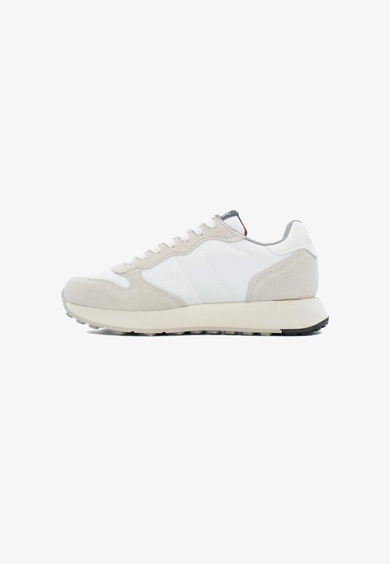Sneakers grigi chiari e bianchi che presentano una combinazione di materiali in pelle e suede, con una suola testurizzata e accenti di design minimalista.