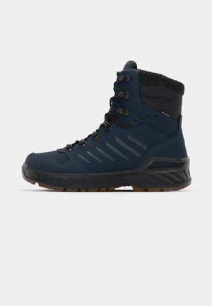Navy hiking boots with a high shaft, textured surface, black accents, rubber sole, and metal eyelets for laces. Waterproof and durable design.