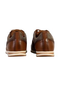 Sneaker in pelle marrone e rete con retro arrotondato, suola piatta bianca e lacci marroni. Accenti grigio chiaro lungo la parte superiore.