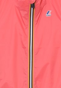Giacca a vento leggera di colore rosa brillante con colletto alto, zip completa e dettagli a righe multicolore lungo la zip. Logo K-WAY visibile.