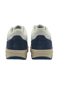 Sneakers blu navy e crema presentano una tomaia in rete testurizzata, dettagli in camoscio e una spessa suola beige con scanalature per la trazione.