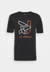 Černé bavlněné tričko s grafickým potiskem loga Air Jordan s bílými a oranžovými akcenty. Krátké rukávy a kulatý výstřih.