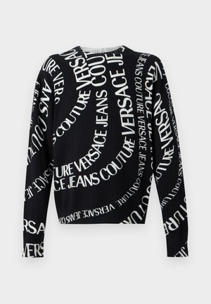 Czarny sweter z długim rękawem z białym napisem "Versace Jeans Couture" nadrukowanym w wirujące, ukośne wzory na całej tkaninie.