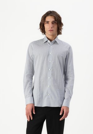 Button-up shirt in light blue, featuring a geometric pattern with small dots. Long sleeves and a classic collar, made of smooth fabric.