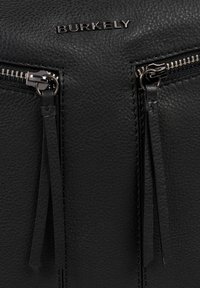 Borsa in pelle nera con due tasche con zip dotate di tirazip con nappine, nome del marchio "BURKELY" in rilievo e superficie testurizzata.