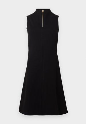 Mouwloze zwarte jurk tot op de knie met hoge kraag en goudkleurige rits aan de voorkant, afgebeeld op een effen achtergrond.