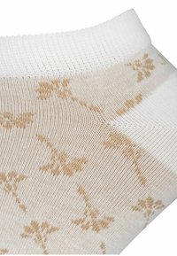 Ankelstrømpe med en hvid ribkant og en lys beige krop med et blomstermønster. Materialet virker blødt og tekstureret.