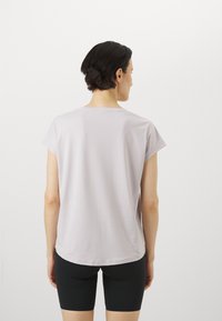 Lyse lilla, kortermet t-skjorte med en avslappet passform, med rund hals og glatt tekstur, brukt sammen med svarte shorts.