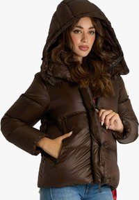 Giacca imbottita marrone con cappuccio, caratterizzata da un design trapuntato, tasche con zip e una texture liscia. Ha una vestibilità comoda e polsini aderenti.