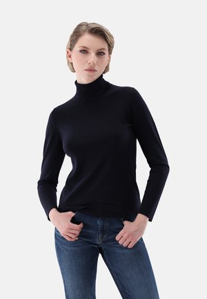 Navy turtleneck sweater made from soft fabric with long sleeves, fitted shape, and ribbed hem. Paired with dark blue jeans.