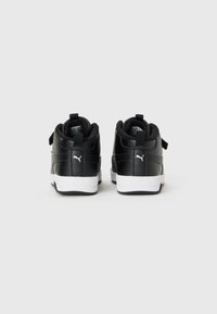 Baskets montantes en cuir noir avec semelles blanches, dotées de cols rembourrés, de lacets noirs et d'un petit accent de logo. La vue arrière montre des languettes de traction.