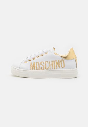Baskets en cuir blanc avec un accent doré au talon, épaisse semelle blanche et "MOSCHINO" en paillettes dorées sur le côté. Œillets et lacets inclus.