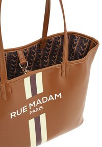 Borsa a tracolla in pelle marrone con strisce bianche e marroni scure. L'interno presenta una foderatura a motivo nero e marrone. Logo esposto sul davanti.