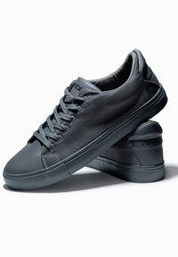 Grå sneakers med ett strukturerat meshuppdrag och slät gummisula. Har rund tå, vadderad krage och dekorativ sömnad.