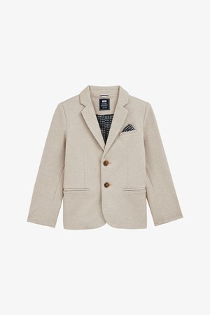 Bēša žakete, kas izgatavota no teksturēta auduma, ar sakostiem atloks, diviem pogām un divām priekšējām kabatām. Iekļauta rakstaina kabatas kvadrātveida paliktnis.