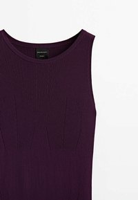 Haut sans manches en maille côtelée de couleur violet foncé avec un col rond et un motif texturé subtil sur le devant.